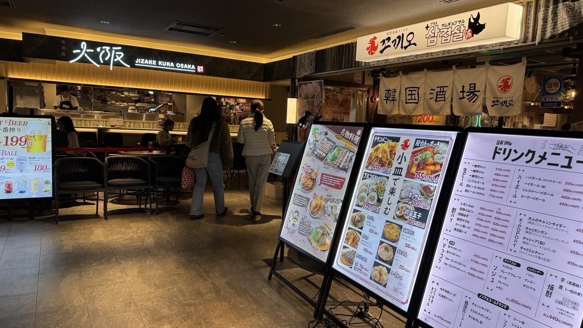 地酒蔵大阪と韓国酒場の店頭に並ぶメニュー看板と客席
