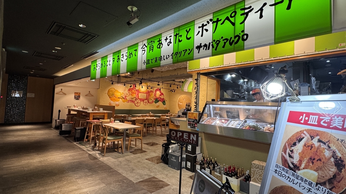 緑の看板が目立つサカバダアレグロのオープンキッチンと客席