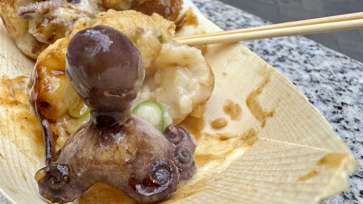 たこ焼きから取り出したイイダコの頭と足が木皿の上に置かれたアップ