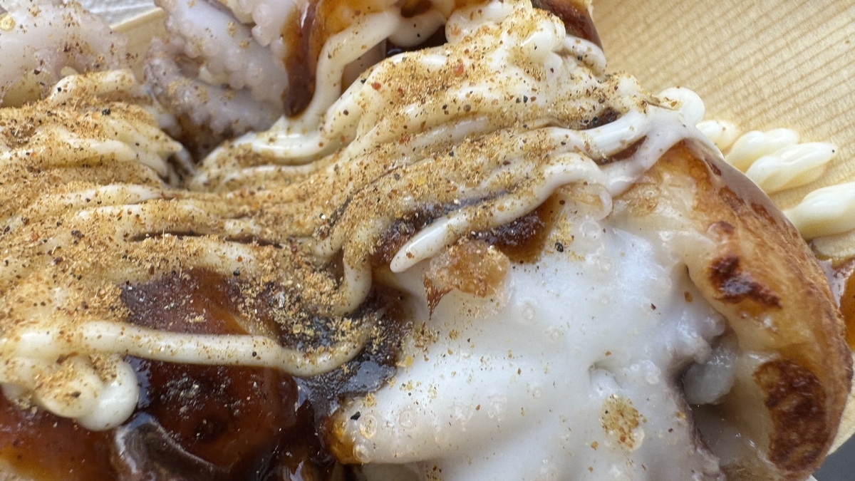 ソースとマヨネーズと青のりをたっぷりかけたたこ焼きのアップ