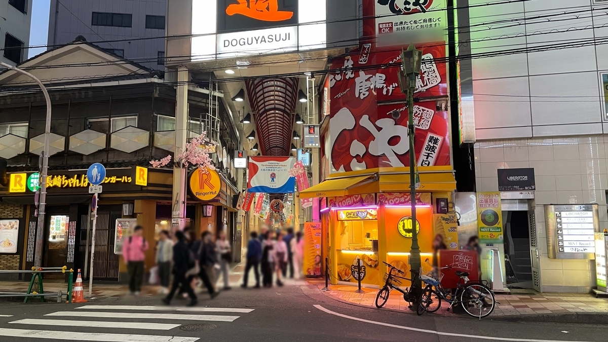 千日前道具屋筋商店街の入口看板と赤いアーチの通りに集まる夜の人通り