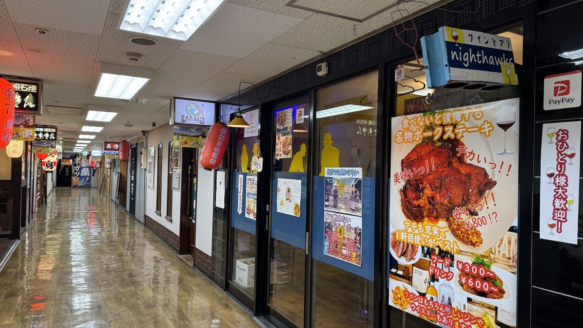 新梅田食道街の2階通路に並ぶ店舗とnighthawksの入口 ポークステーキの大きな看板が目立つ外観