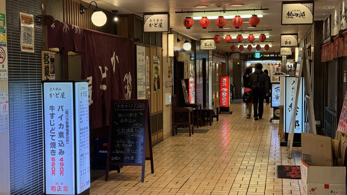 赤提灯が連なる阪急かっぱ横丁の通路と飲食店の暖簾や立て看板
