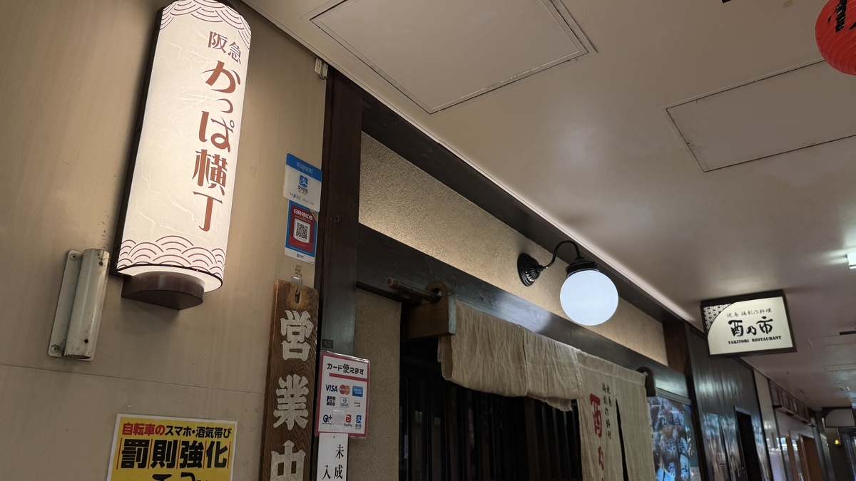 阪急かっぱ横丁の行灯看板と営業中札が見える和食店の店先