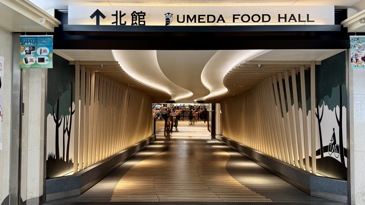 中央の時計モニュメントを囲むUMEDA FOOD HALLの共有席エリアと周囲の店舗