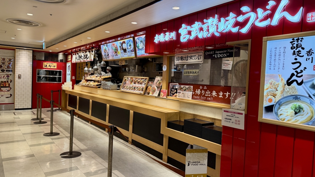 赤い外壁に大きな店名が映える宮武讃岐うどんの長い注文カウンター