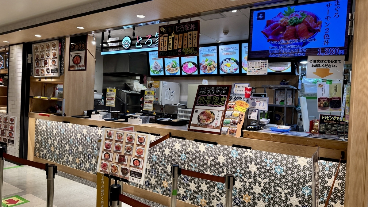 海鮮丼の写真付きメニューボードが並ぶ大阪堂島とろ家の注文カウンター