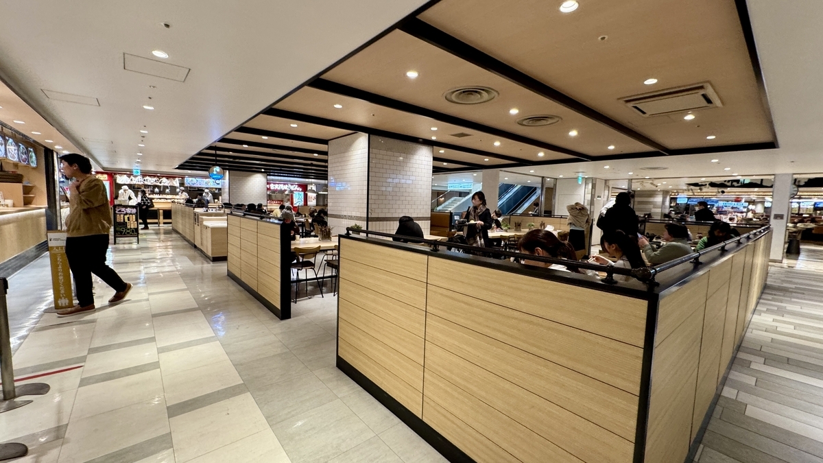 木目の仕切り席が連なるUMEDA FOOD HALLの広いダイニングエリア