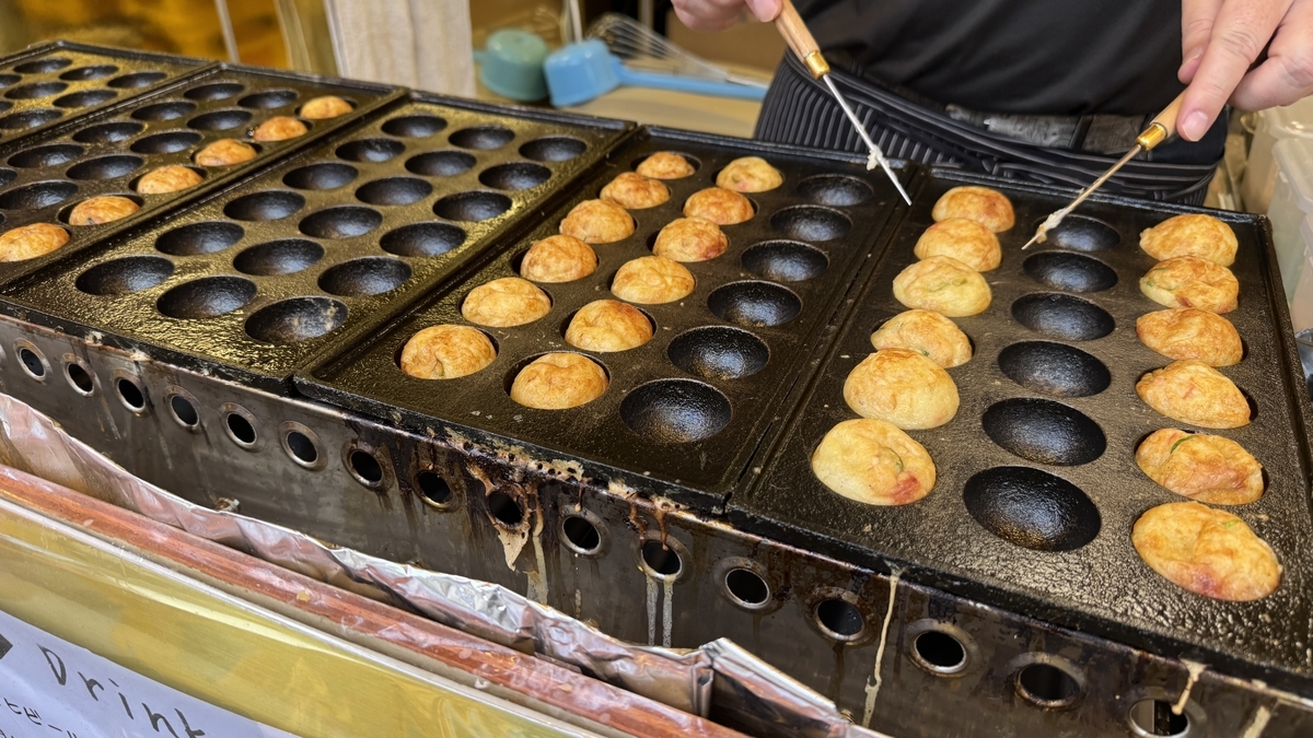 焼き台でたこ焼きを返している調理の様子