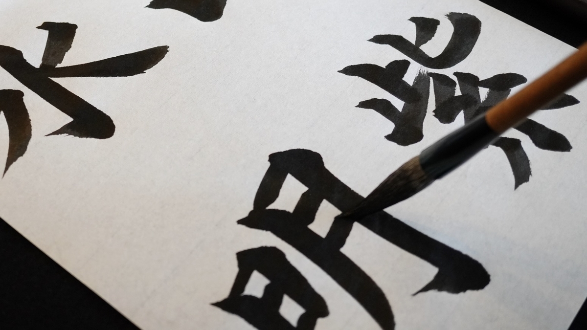 大きな漢字を筆で書く書道の手元