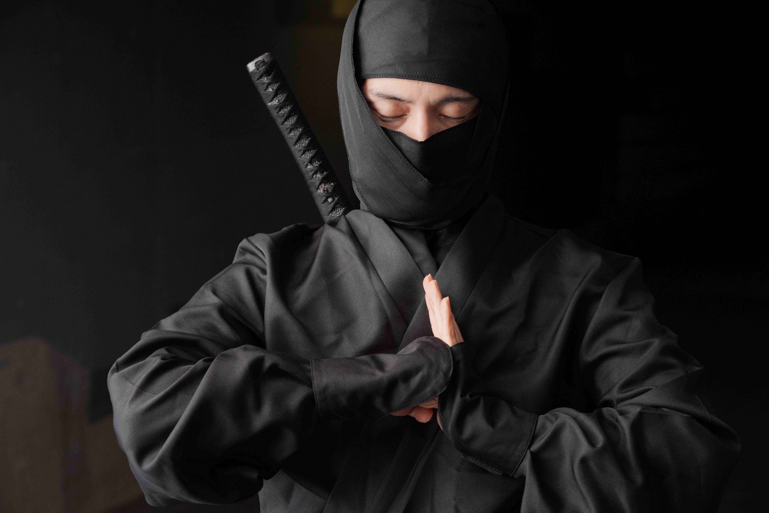 黒装束で印を結ぶ忍者姿の人物