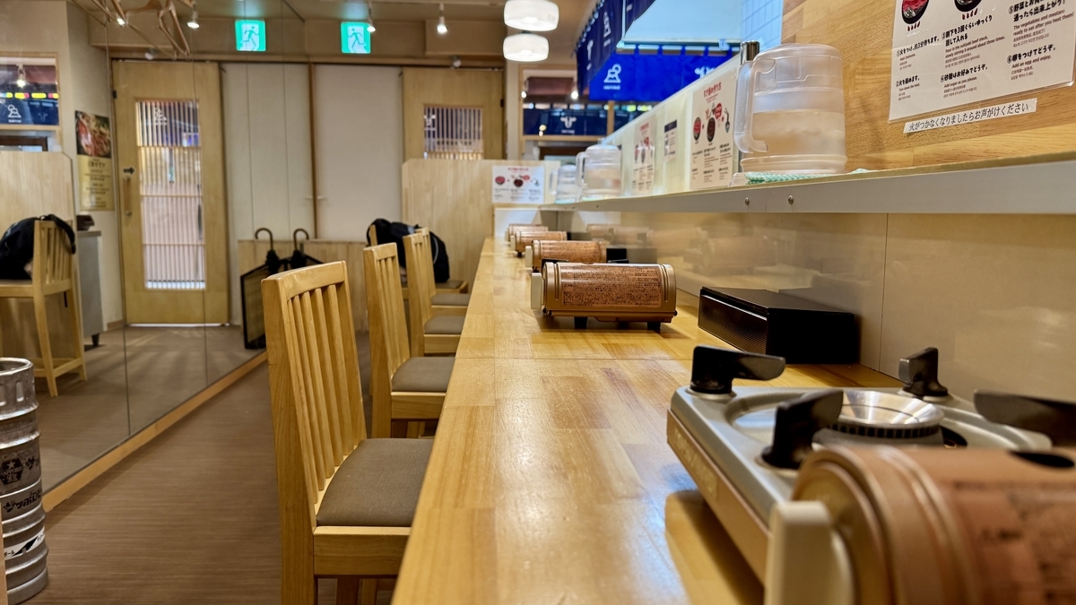 一人用コンロが並ぶ木目調のカウンター席