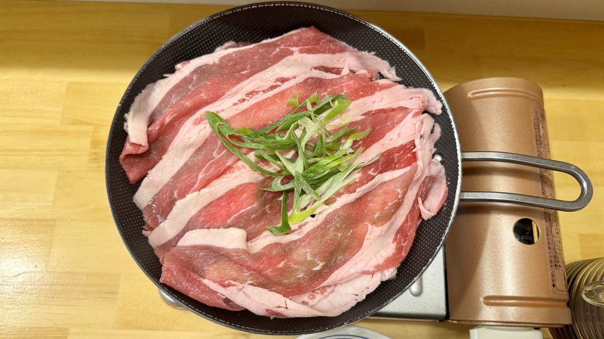 鍋いっぱいに盛られた黒すき焼きの特選牛肉