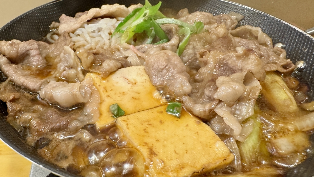 火が通った牛肉と豆腐とネギのすき焼き