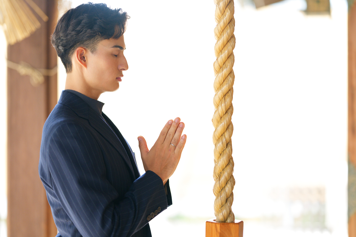 拝殿の前で手を合わせる参拝者