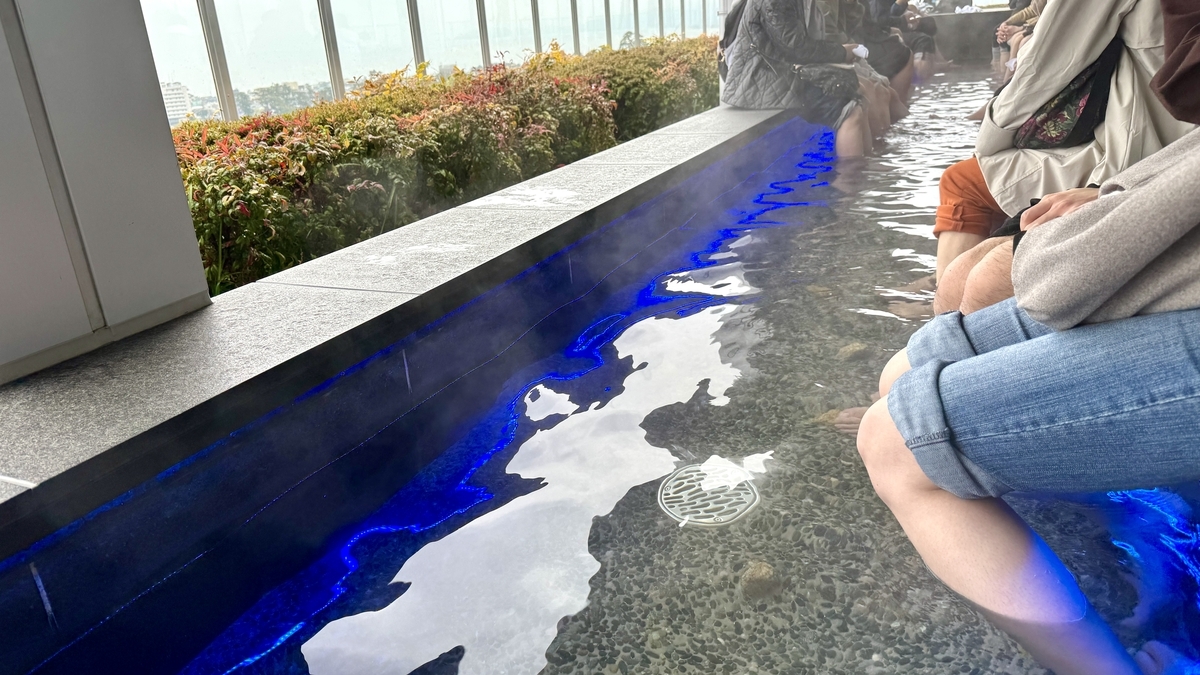 利用者が足を浸す展望足湯庭園の湯船
