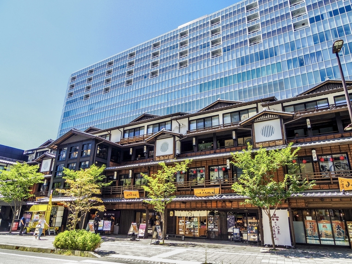 宿場町風の木造商業施設と背後の高層タワーが並ぶ小田原新城下町