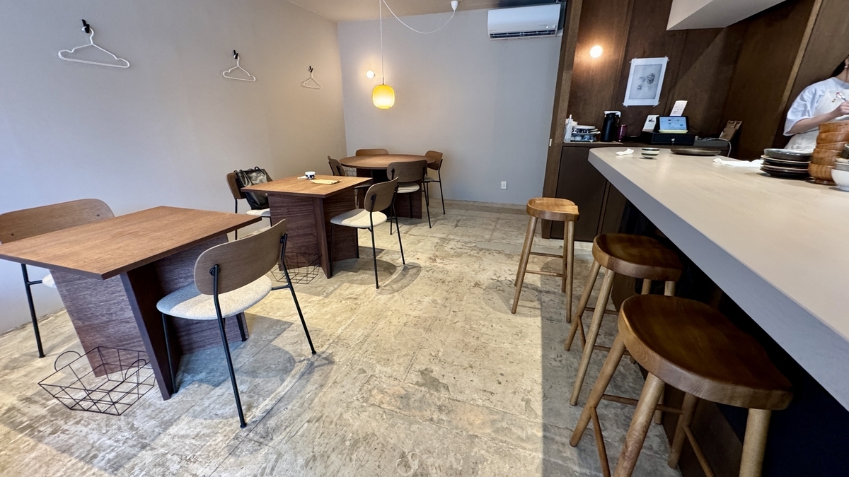 木のテーブルとカウンター席が並ぶこめじるしの店内