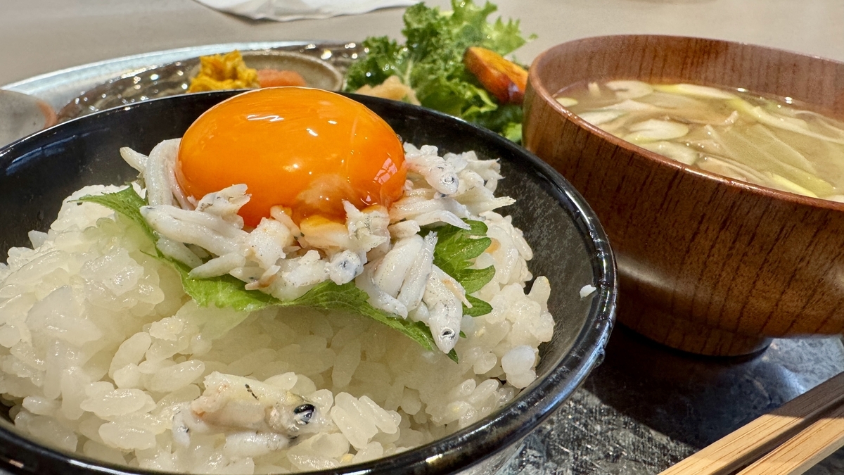 大葉としらすの上に卵黄をのせた羽釜炊きご飯