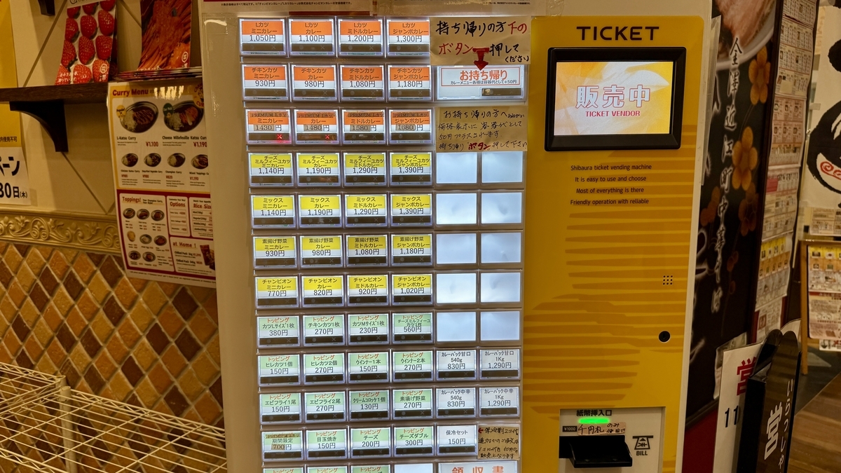 サイズ別のカツカレーやトッピングが並ぶ店内の券売機