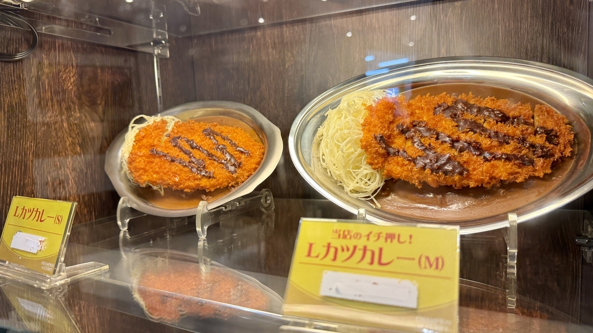 ショーケースに飾られたLカツカレーのサイズ違いの食品サンプル