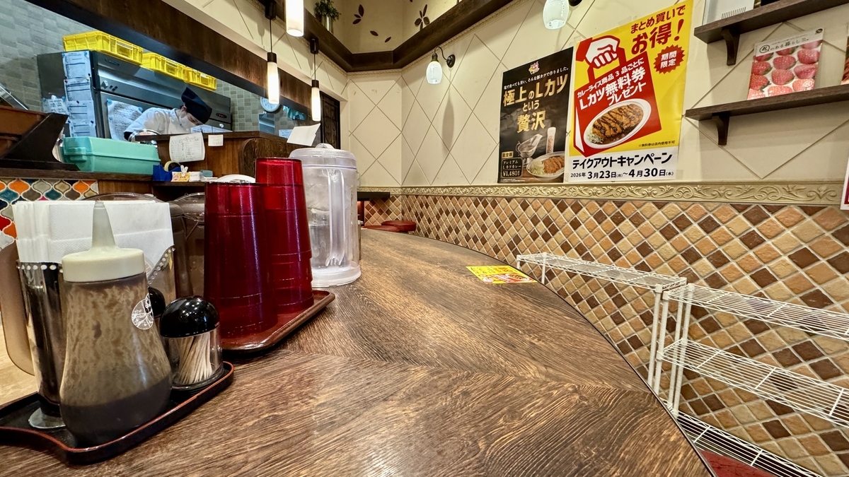 調味料と給水用品が置かれたチャンピオンカレー近江町店のカウンター席