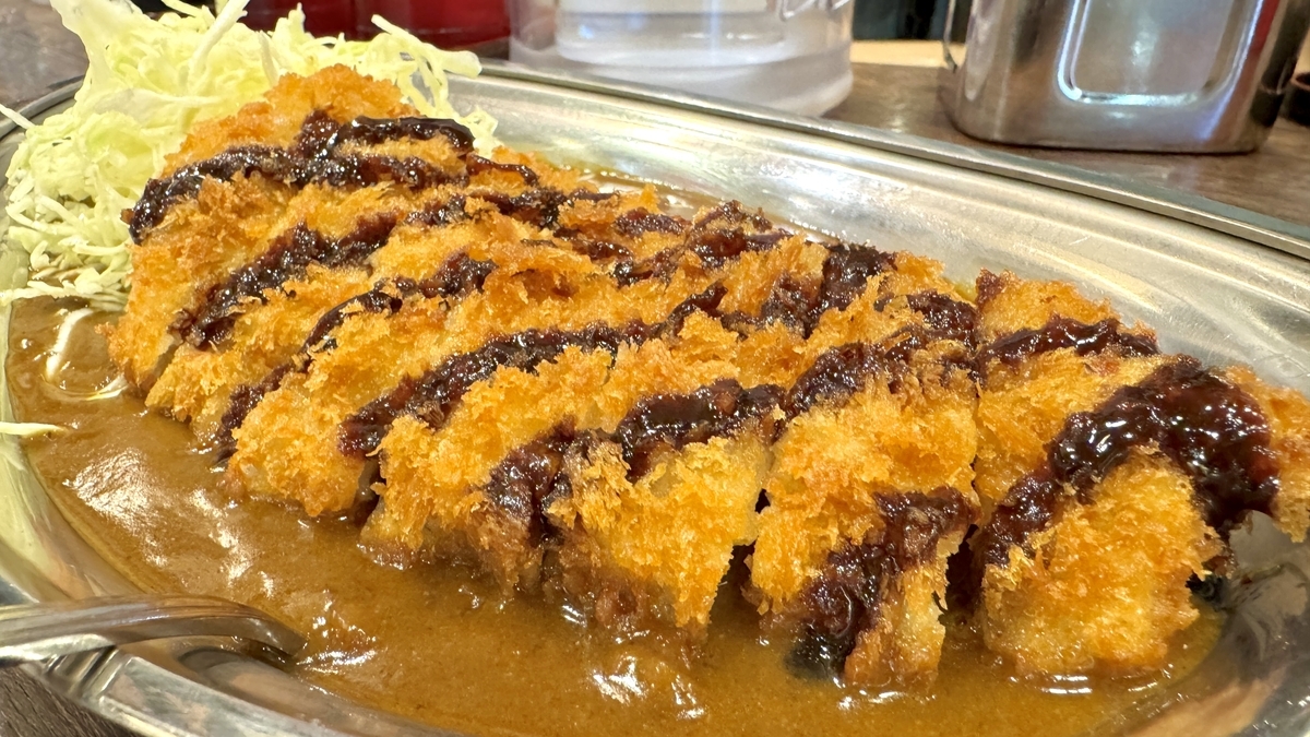 濃厚なカレールーにのったソース付きLカツのアップ