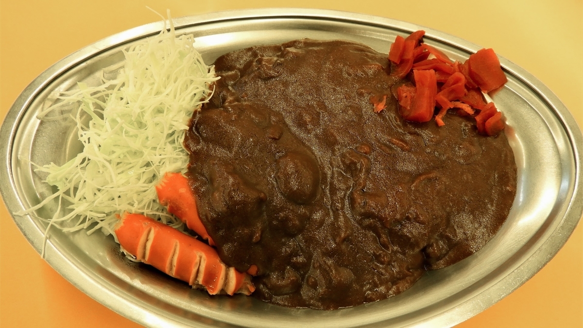 カレーの市民アルバの赤いウインナーと千切りキャベツを添えたカレー