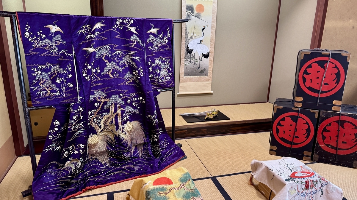 紫地に鶴を刺繍した花嫁衣装と家紋入りの長持