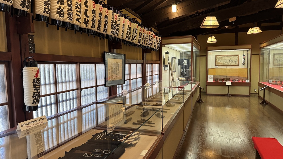 老舗の提灯が天井に連なる百年展の展示室