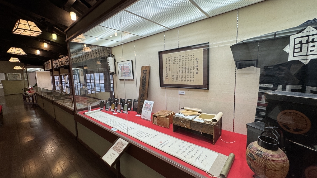 商家の古文書や看板が並ぶ百年展の展示ケース