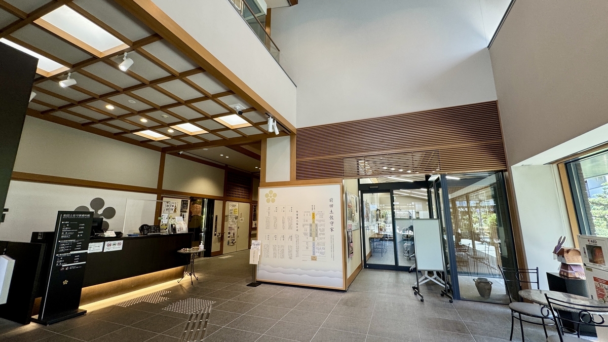 受付カウンターと案内パネルがある前田土佐守家資料館のエントランスホール