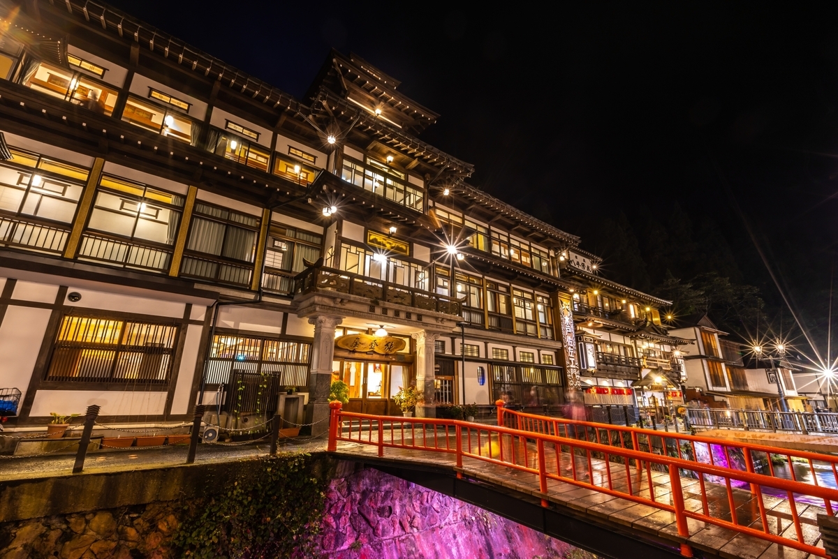 夜の温泉街に明かりをともす木造の温泉旅館