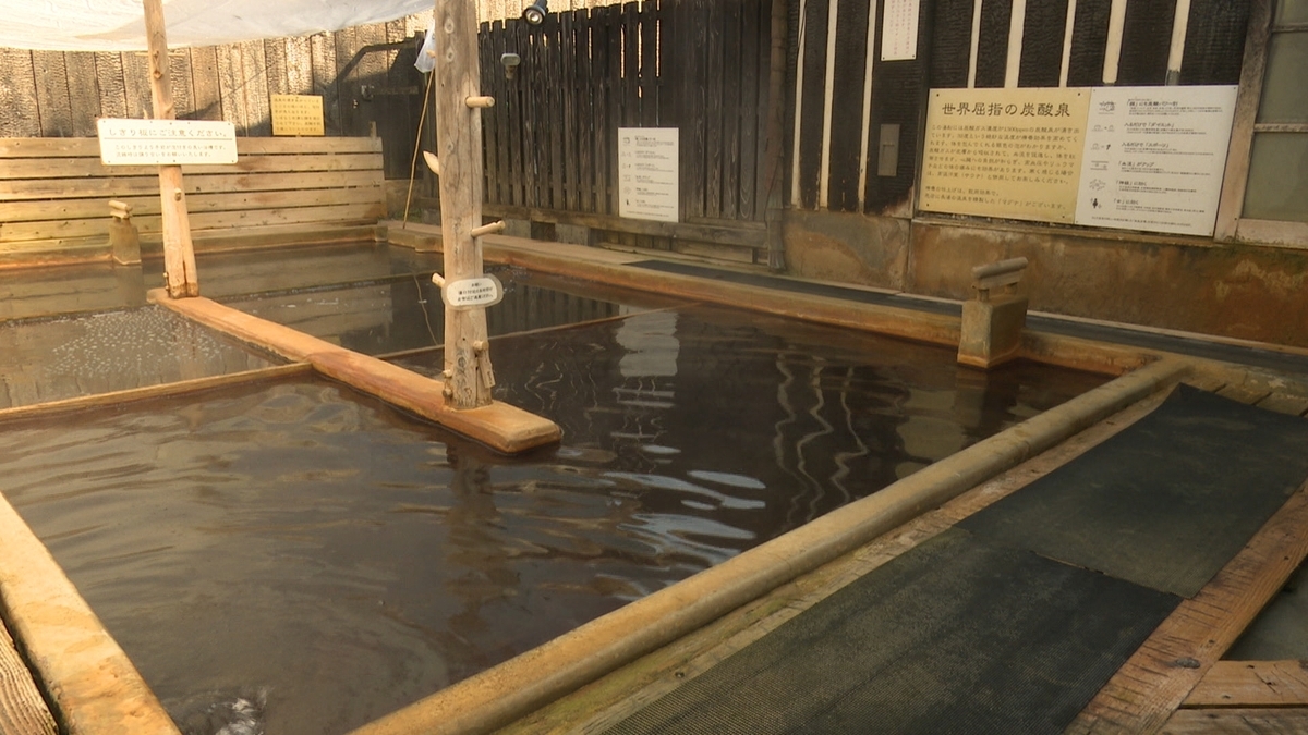 木枠の浴槽に炭酸泉が満ちる長湯温泉の湯船
