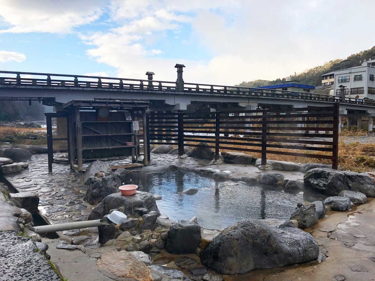 川沿いにある石造りの露天風呂と湯けむり