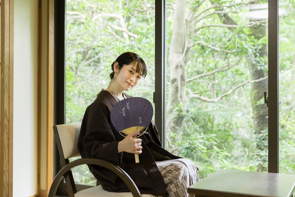 湯上がり処でうちわを持って休む浴衣姿の女性