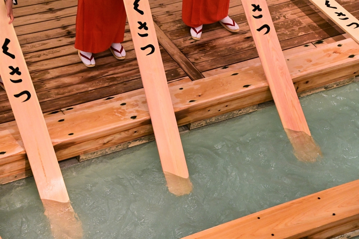 草津温泉の湯もみで木板を湯に入れる様子