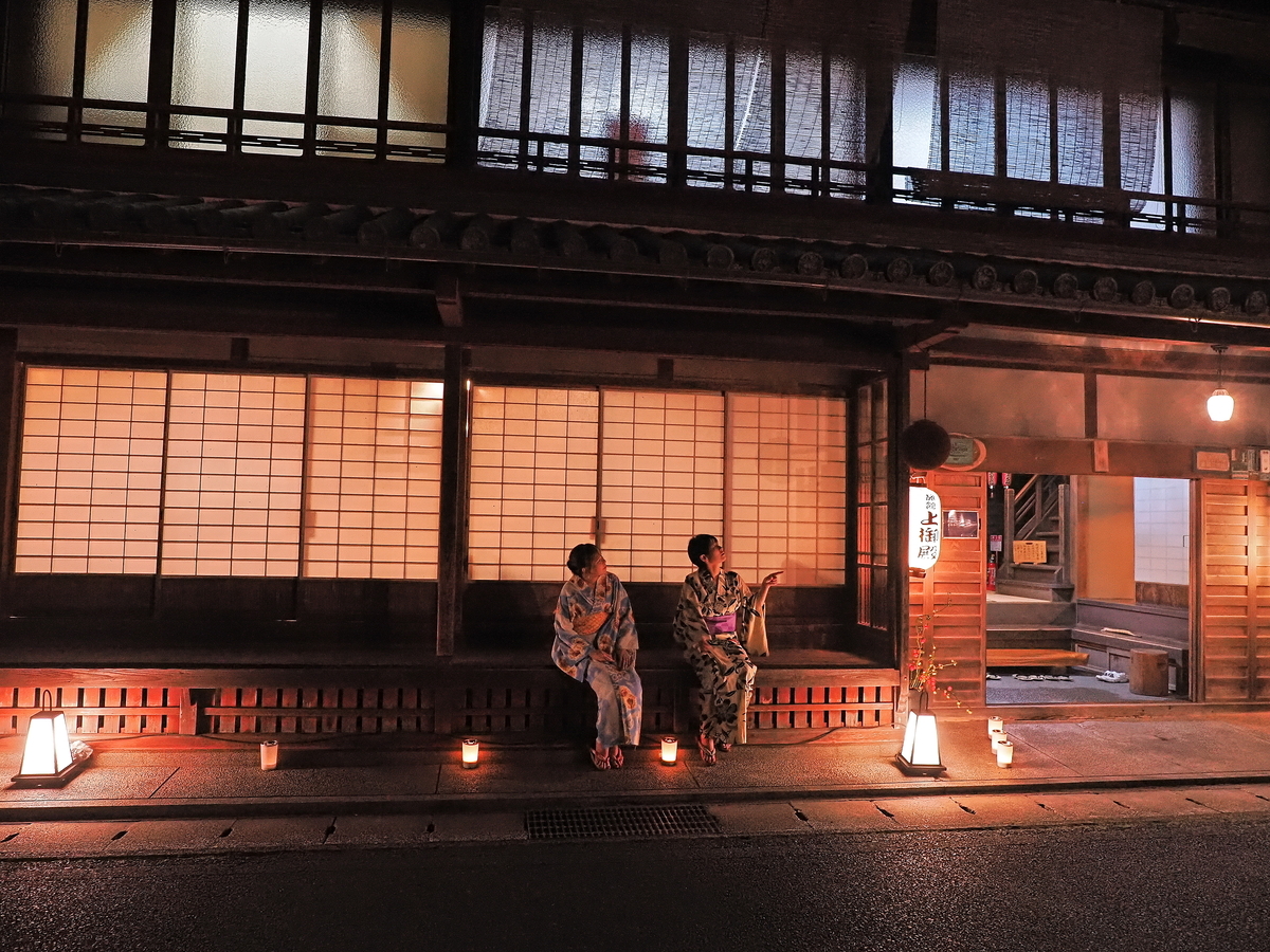 夜の龍神温泉で浴衣姿の人が宿の前に座る風景