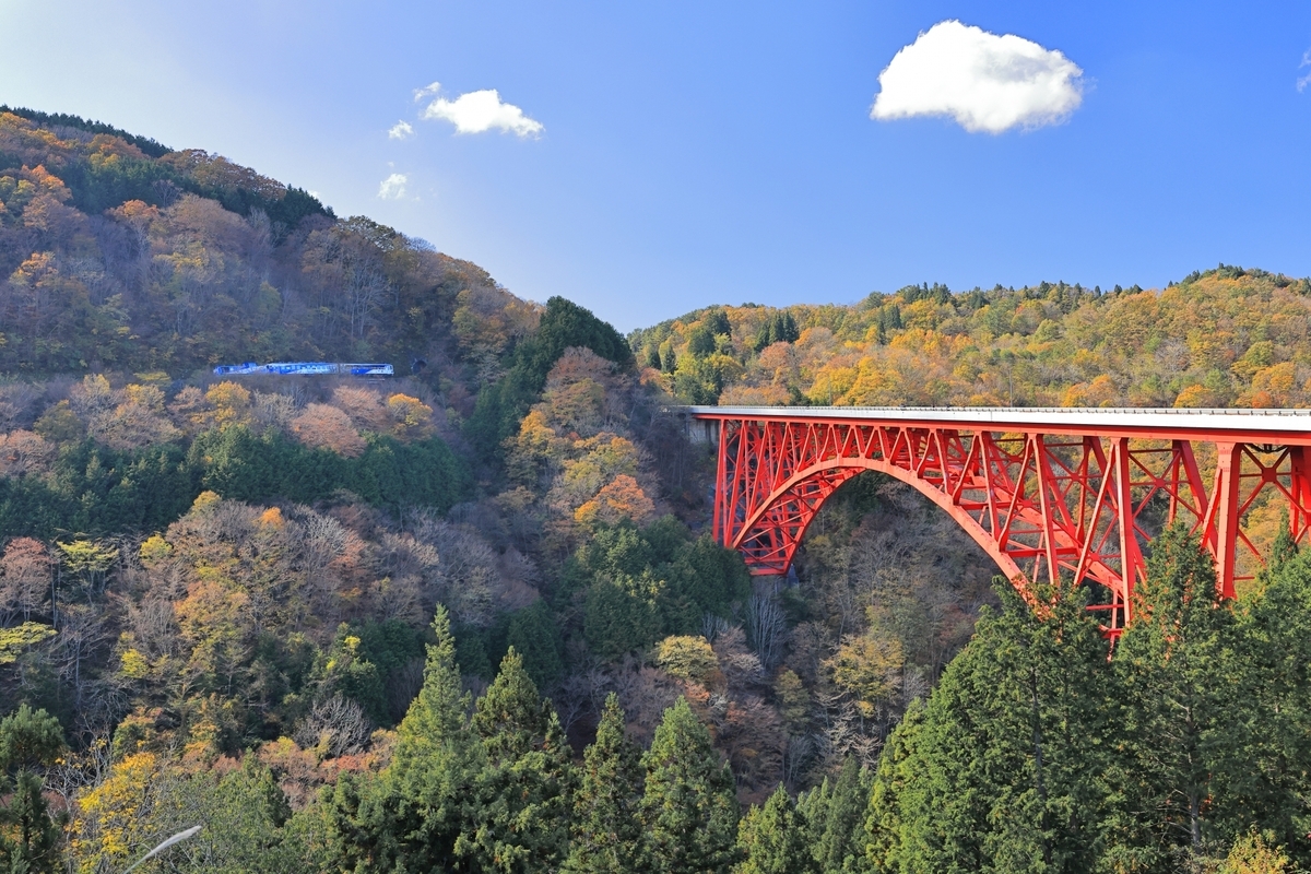 奥出雲の山あいに架かる赤い橋と秋の森