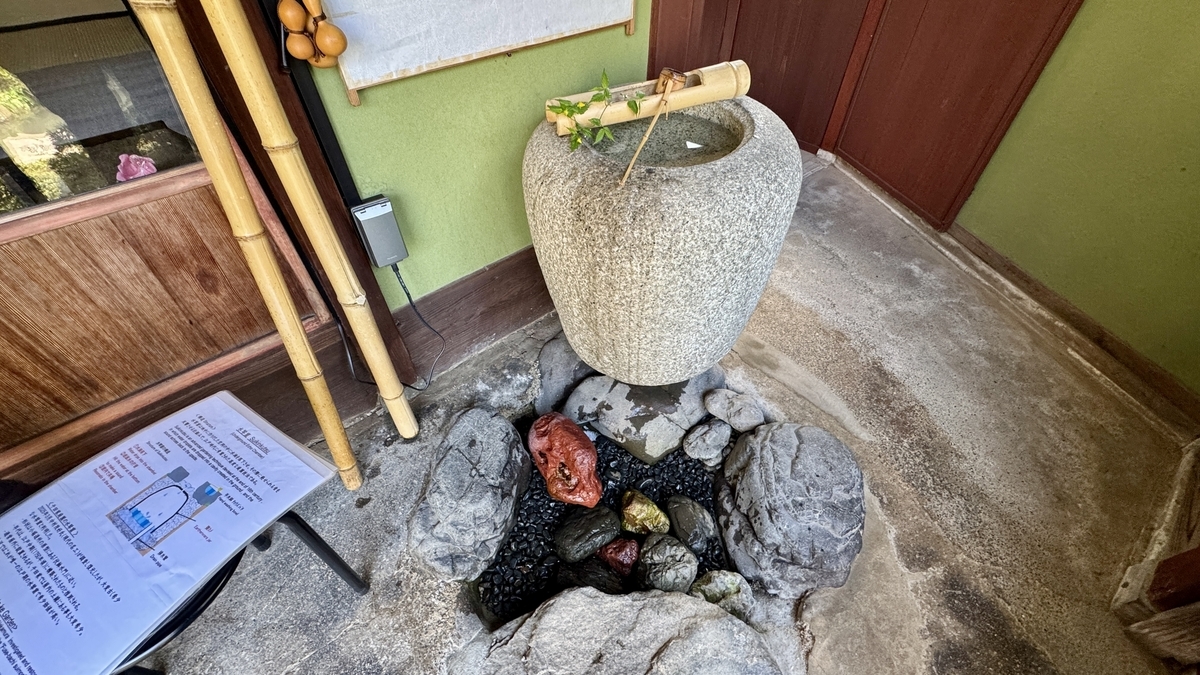 千田家庭園にある水琴窟の手水鉢と説明パネル