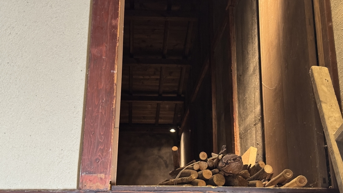清水家の屋根裏あまに置かれた薪と木組みの内部