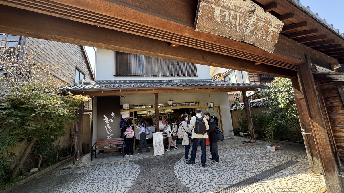 門の奥で観光客が集まる三の橋付近の土産店