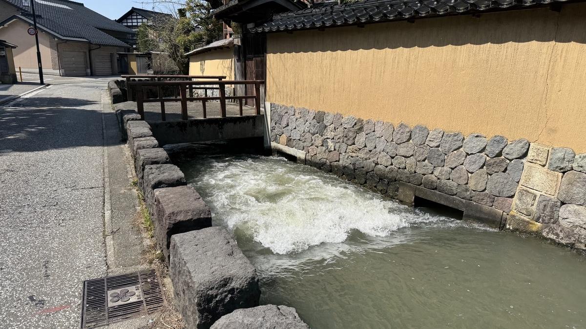 土塀の脇を流れる大野庄用水と小さな橋