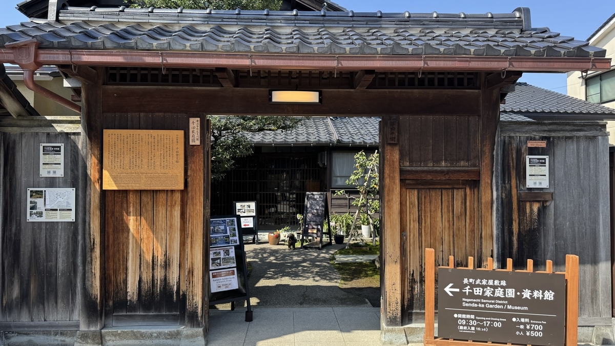 千田家庭園と資料館の案内がある木造門