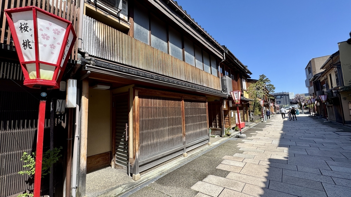 桜桃の提灯と木格子の茶屋建築が並ぶ通り