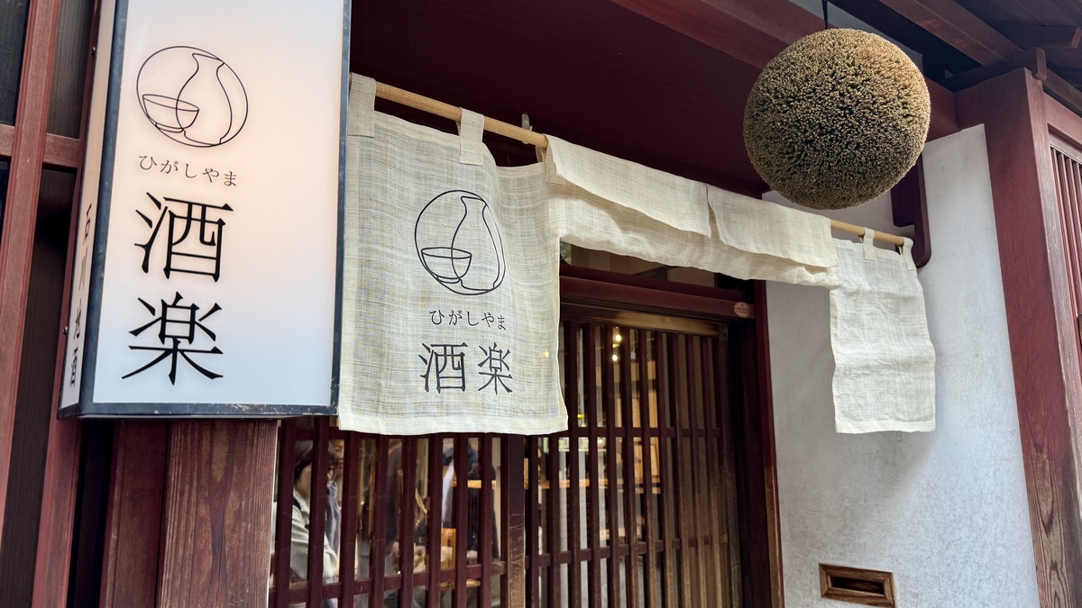 杉玉と白い暖簾がかかる酒楽の店先