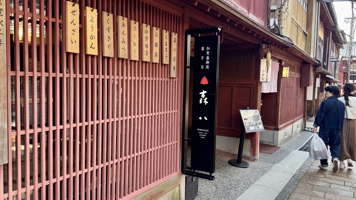 紅殻格子と菓子の札が並ぶ森八の店先