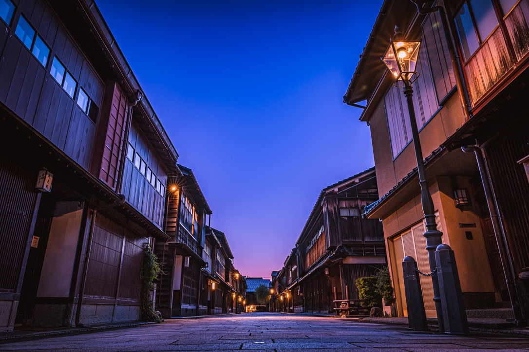 夕暮れの青い空と街灯に照らされたひがし茶屋街の通り