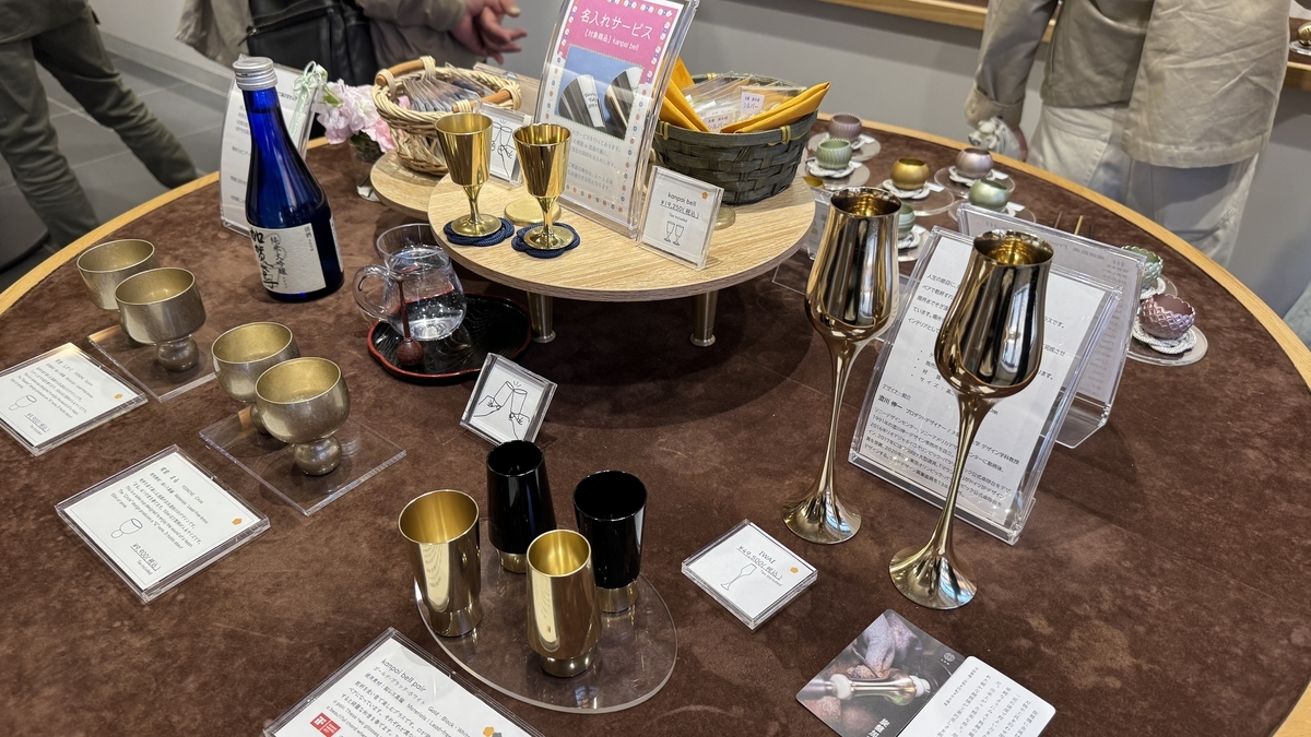 小泉屋金沢店に並ぶ金色の酒器とグラス
