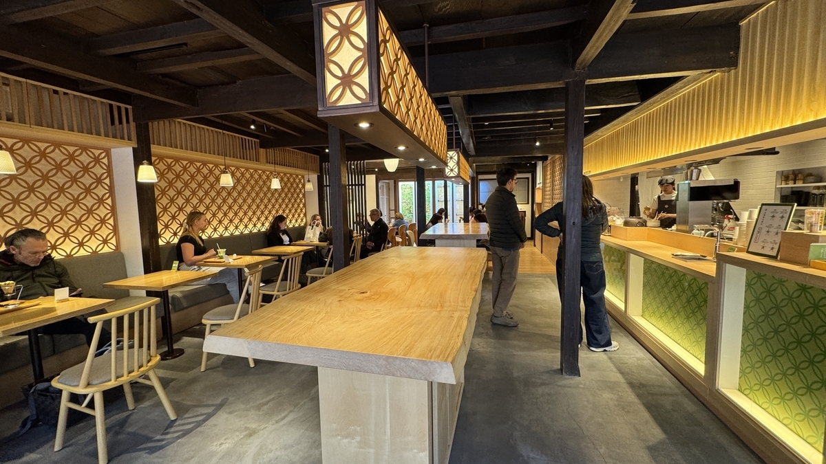木の大テーブルと客席がある抹茶館の和モダンな店内